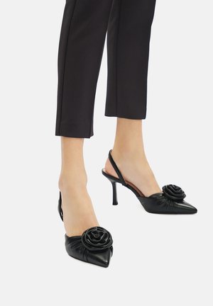 Čierne kožené slingback podpätky s špicatými prstami, zdobené akcentom v tvare ruže na priehlavku a textúrovaným, zhrnutým dizajnom.