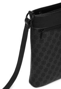 Black shoulder bag with a textured pattern, featuring a smooth leather top and a zippered pocket. Adjustable strap for versatile carrying.