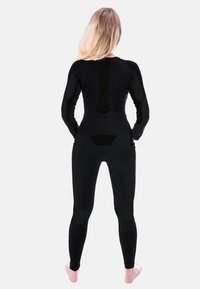 Black long-sleeve bodysuit with fitted design and textured paneling. Smooth material with minimal seams and ankle-length legs.