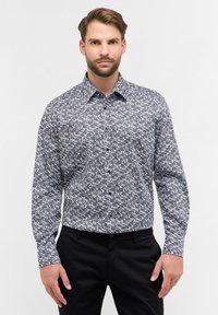 Langarm overhemd met een zwart-wit abstract patroon, gemaakt van een gladde stof met een gestructureerde kraag en manchetten.