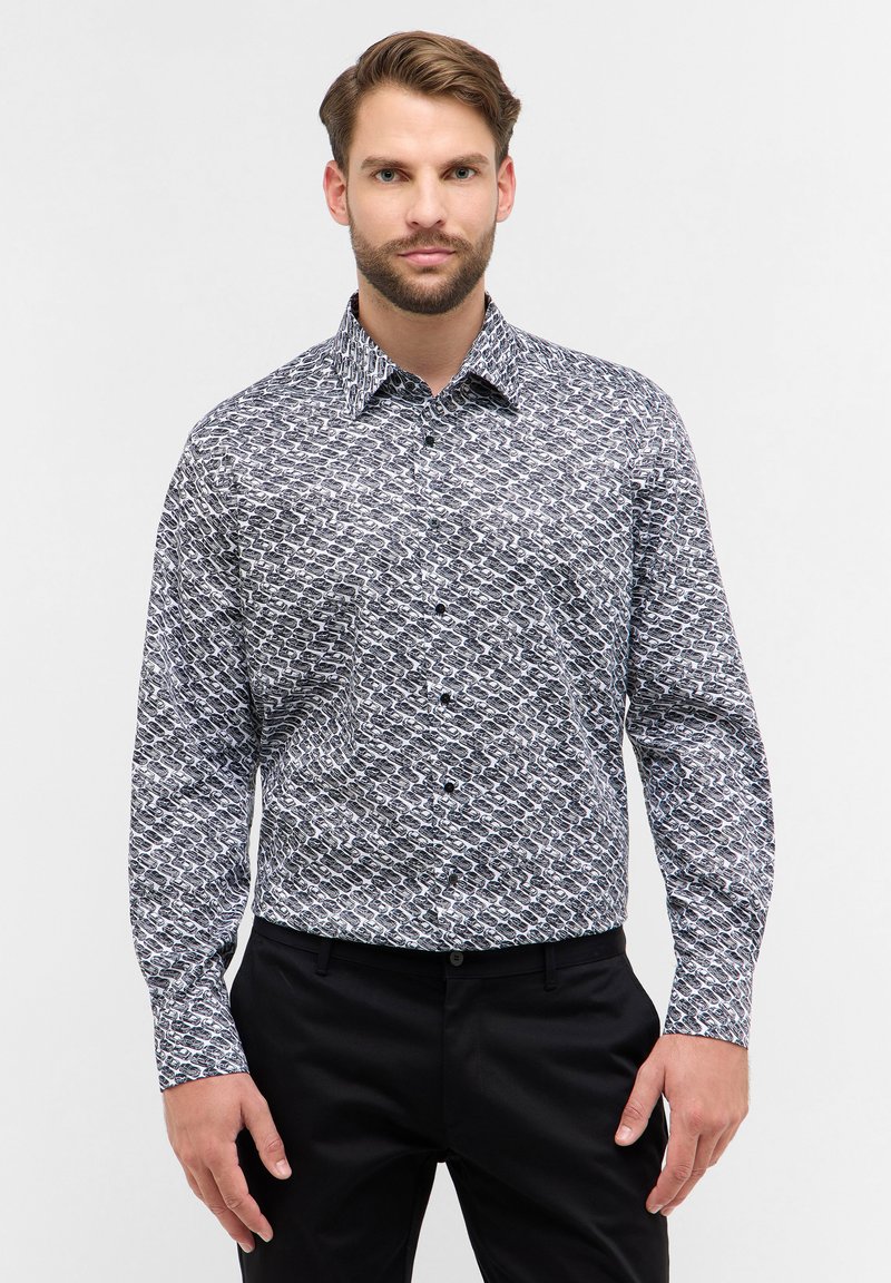 Camicia con maniche lunghe e bottoni, caratterizzata da un motivo astratto in bianco e nero, realizzata in un tessuto morbido con colletto e polsini strutturati.