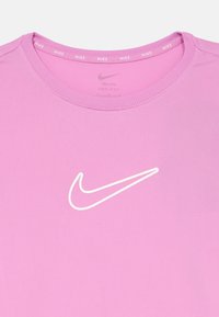 Rosa Nike Dri-FIT skjorte med hvit omriss av Nike swoosh-logoen sentrert under halsen.