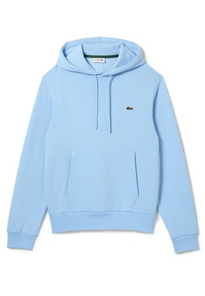 Jasnoniebieska bluza z kapturem z przednią kieszenią, kaptur z regulowanym sznurkiem, ściągacze na rękawach oraz małe zielone logo krokodyla Lacoste na piersi.