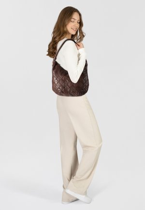 Brown leather quilted handbag with a soft texture, featuring a prominent shoulder strap and decorative anchor hardware.