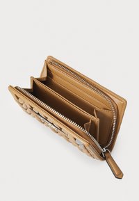 Tan leather wallet with a textured, puffy design. Features a zip closure, multiple card slots, and two open compartments. Silver hardware accents.