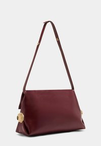 Dieprode leren schoudertas met een enkele verstelbare strap en gouden geometrische metalen accenten aan beide kanten.