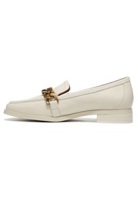 Light beige leather loafers with a low block heel, featuring a decorative gold chain accent and clean stitching details.