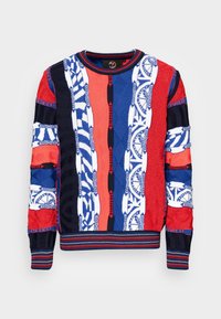 Trui met een patchworkontwerp in rood, blauw en wit. De stof is gegarneerd met verschillende patronen en heeft ribgebreide manchetten en onderrand.