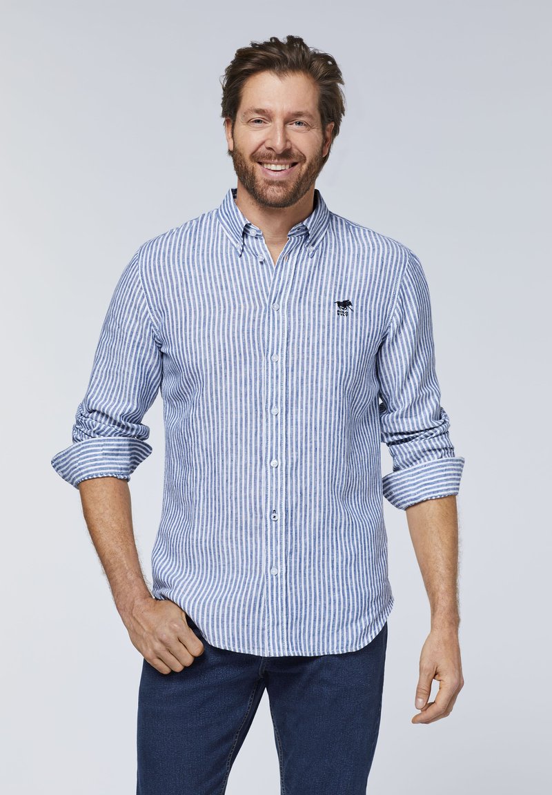 Blau-weiß gestreifte Bluse mit Knopfschluss, langen Ärmeln, die an den Bündchen aufgerollt sind, und einem kleinen gestickten Logo auf der Brust.