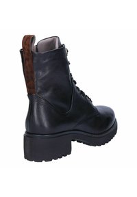 Zwarte leren enkellaarzen met een gestructureerde bruine luipaardprint accent aan de achterkant, dikke rubberen zool en vetersluiting aan de voorkant.