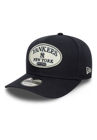 Gorra de béisbol negra con un gran logo bordado de los Yankees en blanco, con "Est. 1903" debajo y una correa ajustable en la parte trasera.