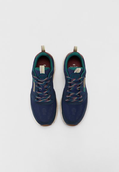 Chaussures de sport bleu marine avec un tissu en mesh, des lacets colorés et une semelle texturée. Présente un logo distinctif et une languette de traction rayée au talon.