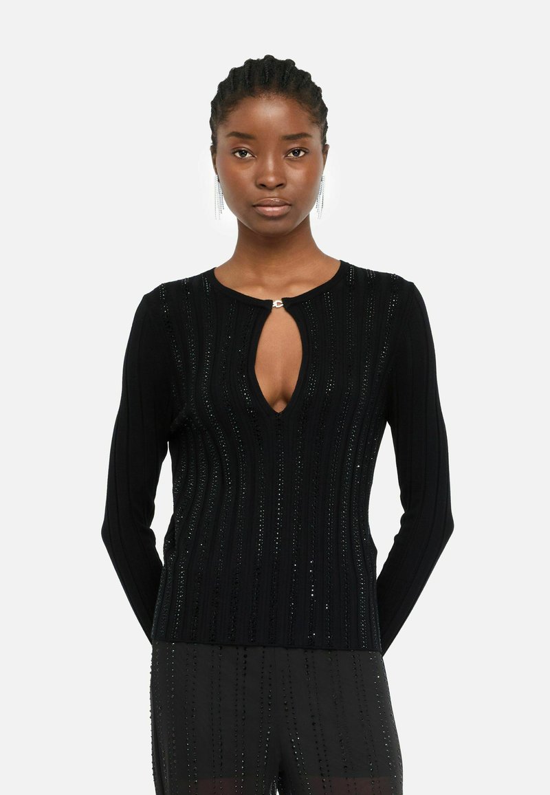 Maglione nero a costine con scollatura a V profonda, decorato con paillettes orizzontali, maniche lunghe e un piccolo dettaglio metallico all'escollatura.