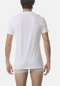 White short-sleeve T-shirt made of soft cotton, featuring a classic crew neck and a slim fit, shown from the back.