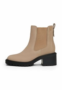 Botte de cheville en cuir beige avec panneau latéral �élastique, semelle noire épaisse, talon carré et petit logo doré près de la boucle arrière.