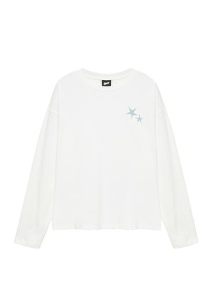 Hvid langærmet T-shirt med rund hals og to små blå stjernedesign på øverste venstre brystområde samt et sort mærke inde i kraven.
