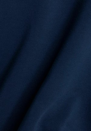 Tela azul oscuro con una textura suave, que muestra un patrón de punto sutil y un drapeado delicado, resaltando su suavidad y flexibilidad.