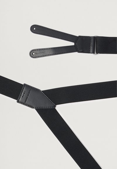 Μαύρες υφασμάτινες τιράντες με δερμάτινες λεπτομέρειες, διαθέτοντας ρυθμιζόμενους ιμάντες και μεταλλικές συνδέσεις, παρουσιάζοντας έναν μινιμαλιστικό σχεδιασμό.
