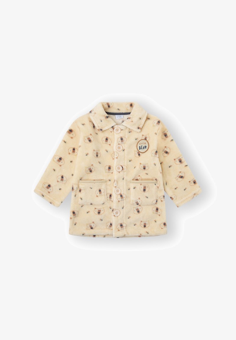 Chaqueta de felpa color crema con patrón de osos, cierre de botones, dos bolsillos delanteros y un parche redondo de "osito" en el lado izquierdo. Textura suave.