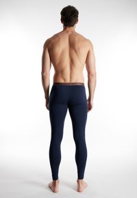 Navy Leggings mit einem enganliegenden Design, aus dehnbarem Material; verfügen über einen braunen Markenbund mit glatter Textur und einer knöchellangen Schnittführung.