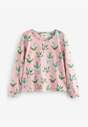 Rozā auduma krekls ar garām piedurknēm, kas izceļas ar ziedu rakstu un zaļām lapām, kā arī zilām detaļām. Apaļa kakla izgriezuma un brīva piegriezuma dizains.