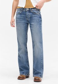 Lys blå denim jeans med rett benklipp, fem lommer og subtil falming. Har knapp- og glidelåsåpning foran.