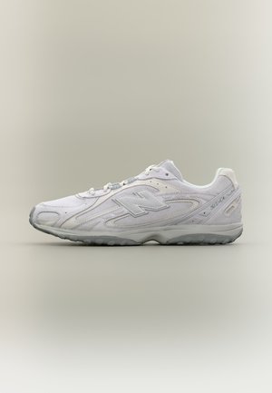 Baltas New Balance 2041 žemas sportbačių modelis su pilku padu, šoniniu logotipu ir tekstūruotu dizainu ant šviesaus neutralaus fono.