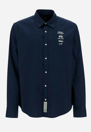 Marineblauw overhemd met lange mouwen, knopen, kraag en witte geborduurde tekst en logo's op de linkerbovenborst.
