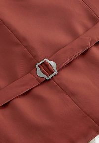Brauner Stoff mit glatter Textur und einem Metallverschluss. Verfügt über ein maßgeschneidertes Design und präzise Nähdetails.