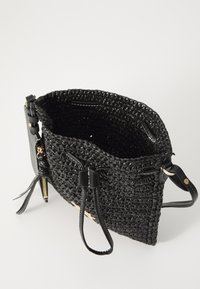 Sort vævet håndtaske med en tekstureret strå-lignende krop. Har sorte læderdetaljer og et rummeligt indre med dobbelt håndtag og justerbare stropper.
