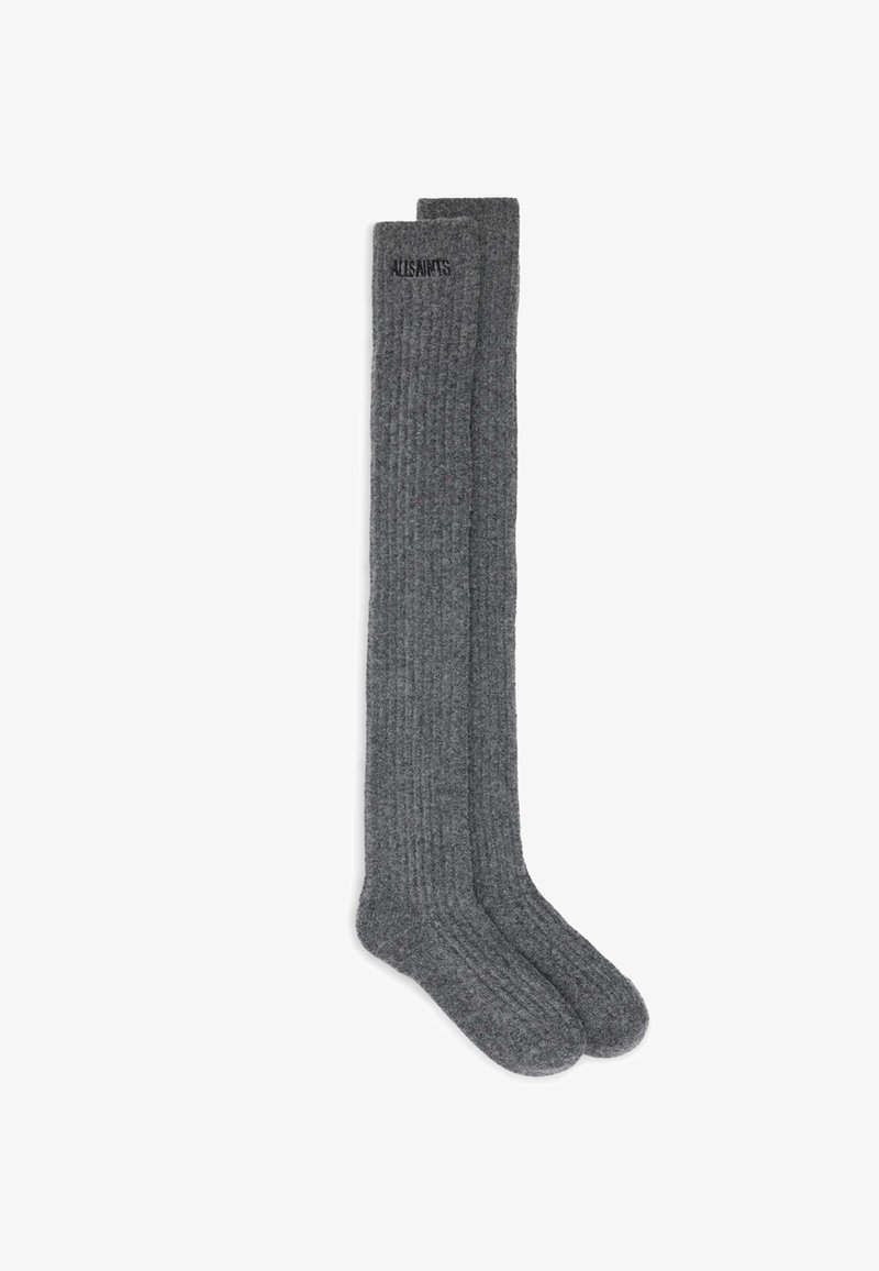 Grå ribbede knæhøje sokker med en blød, tekstureret overflade og subtil branding på den øverste kant. Fremstillet af et komfortabelt strikkemateriale.