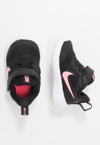 Schwarze Stoff-Sneaker mit pinken Akzenten und einer weißen Sohle. Verfügt über einen Klettverschluss und einen gepolsterten Schaft für Komfort.