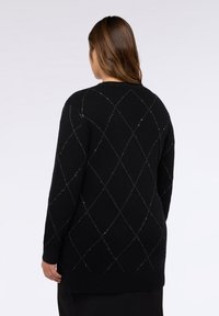 Pulover negru cu un model în diamant, având accente din fir metalic, mansete și tiv cu nervuri, textură moale și croială lejeră.