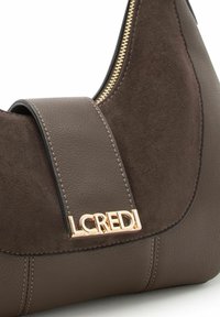Borsa in pelle marrone con dettaglio in camoscio, forma curva, cerniera dorata e logo metallic LCREDI su una tracolla liscia.