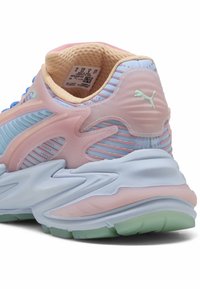 Puma lenkkarit, joissa on pastelliväriharmonia, jossa on kiiltävä vaaleanpunainen ja sininen verkkomateriaali, paksu vaaleansininen pohja ja teksturoidut yksityiskohdat.