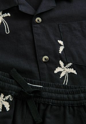 Kortärmad svart skjorta med palmträdbroderi, knäppning och ficka; elastisk midja med dragsko på matchande shorts.