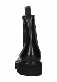 Bota de cuero negro hasta el tobillo con detalles de brogue, puntera redonda, acabado texturizado, suela de plataforma baja y una tira en la parte posterior.