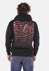 Felpa con cappuccio nera caratterizzata da una grafica colorata con un motivo di gabbia toracica sul retro, dettagli in rete testurizzata e una tasca a marsupio frontale.