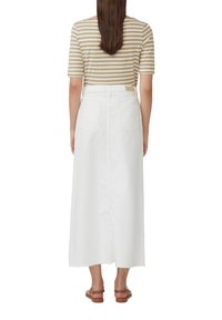 Jupe midi en denim blanc avec ourlet brut, poches arrière, et passants de ceinture, associée à un haut à manches courtes rayé brun et crème.