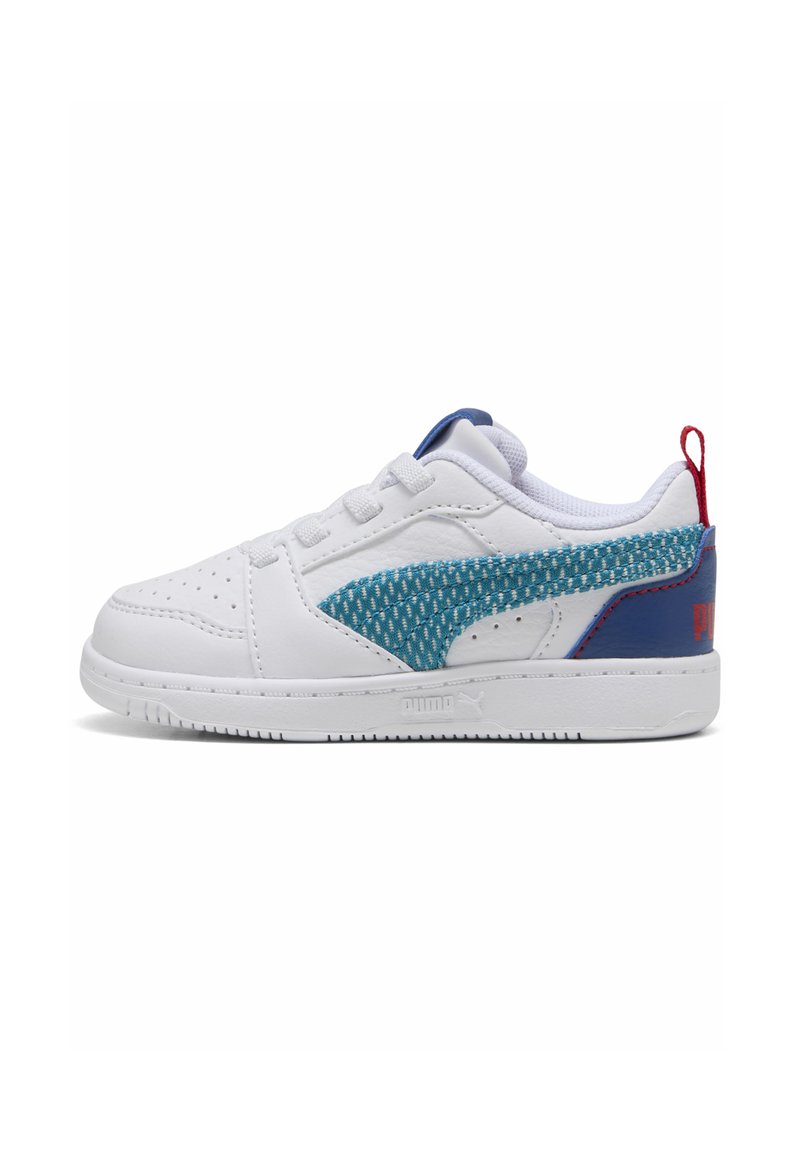 Sneakers bianchi con pannello laterale blu testurizzato, colletto imbottito e accentatura rossa sul tallone. Presentano lacci tradizionali e design della punta perforato.