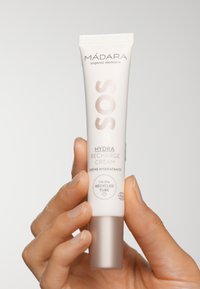 MÁDARA SOS Hydra Recharge Cream i en vit tub med silverdetaljer. Texten inkluderar "HYDRA RECHARGE CREAM" och "Jag är den återvunna tuben."