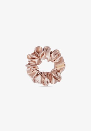Satijnen scrunchie in zacht roze, met een gladde textuur en een gerimpeld ontwerp, biedt rekbaarheid en een decoratief labelaccent.