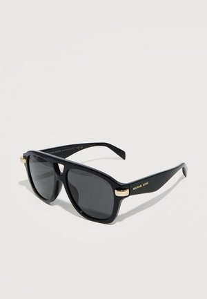 Fekete téglalap alakú napszemüveg sötét lencsékkel, arany díszítéssel a zsanéroknál és "Michael Kors" logóval a szárakon, világos háttéren bemutatva.