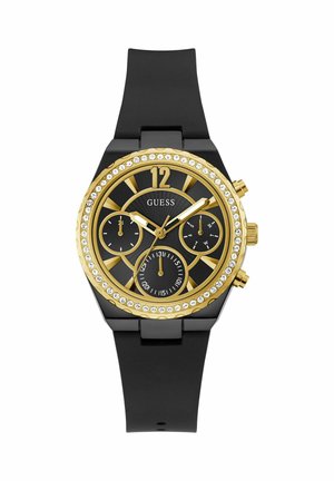 Orologio con cinturino in silicone nero e dettagli dorati, quadrante nero, bezel in cristallo, tre sotto-quadranti e marcatori delle ore in evidenza. Presenta un 12 in alto.