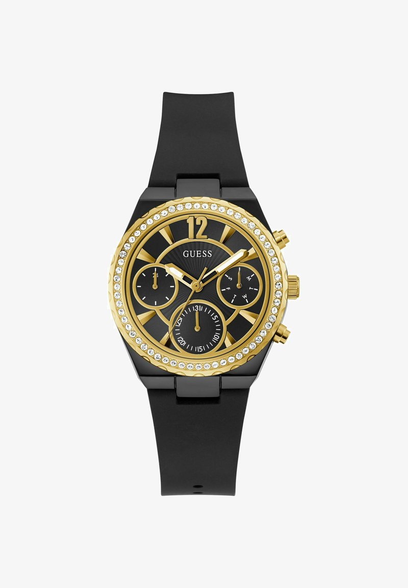 Melnās silikona siksniņas pulkstenis ar zelta akcentiem, melnas krāsas pulksteņu sešs, kristāla apmale, trīs apakšdispleji un drosmīgi stundu marķējumi. Augšpusē ir 12.