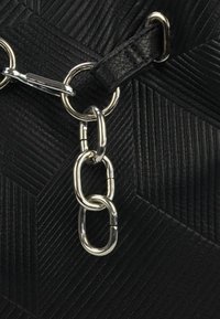 Zwarte leren handtas met een textuur, gekenmerkt door een geometrisch patroon, zilverkleurige kettinghardware en een leren haakbevestiging.