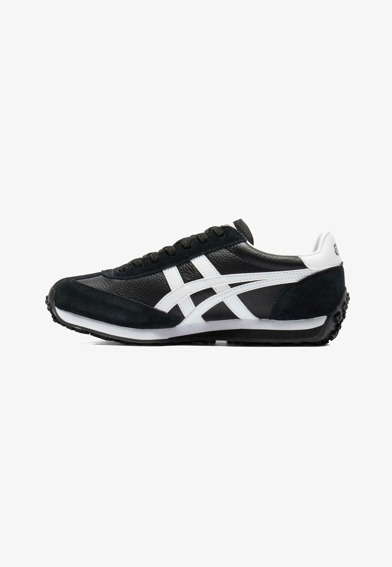 Czarno-biały niskoprofilowy but sportowy z białymi paskami, czarnymi sznurowadłami i teksturowaną podeszwą, pokazany z boku na białym tle.