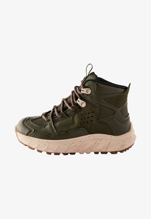 Hochschnitt-Wanderschuhe aus dunkelgrünem synthetischem Material, mit strukturierten Akzenten, braunen Schnürsenkeln und einer beigen, punktierten Sohle mit Profil.