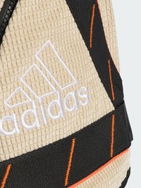 Kreminės spalvos tekstūruotas kuprinė su juodais ir oranžiniais akcentais. Puošia baltas išsiuvinėtas logotipas ir kontrastingos dirželiai, suteikiantys papildomo išskirtinumo.