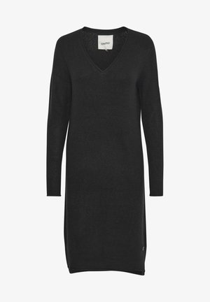 Svart strikket kjole med V-hals, lange ermer og ribbestrikkede mansjetter. Har en sidesplit og en subtil logo detaljer nær kanten.